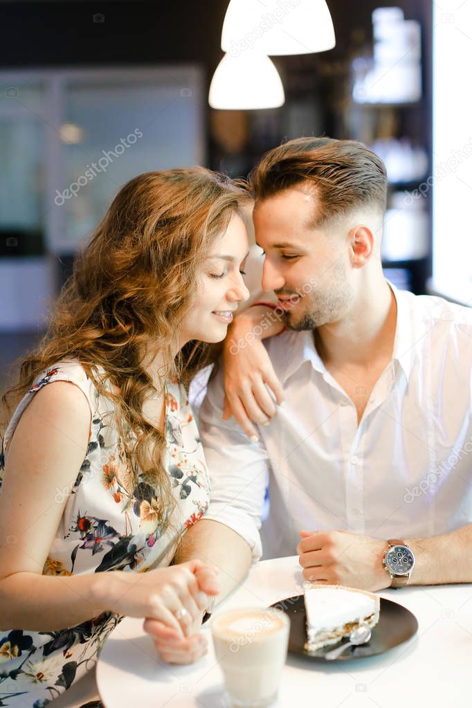 Young european girl and boy sitting at cafe, drinking coffee and resting.