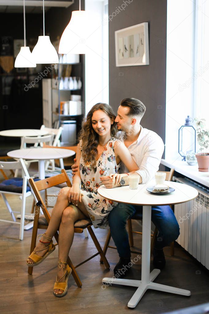 Young happy smiling couple sitting at cafe and resting.