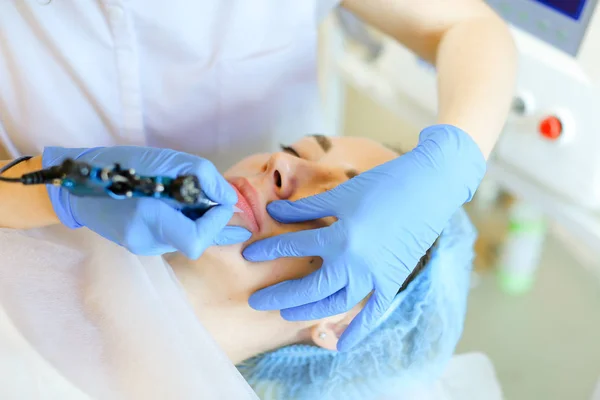 Close up hands in latex gloves making permanet lip tattoo with microblading device at beauty salon. — Stock Photo, Image