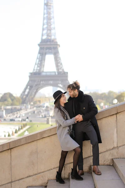 Afro Amerikaanse jongen knuffelen Kaukasische vrouw op betonnen trappen in Parijs, Eiffel toren in de achtergrond. — Stockfoto