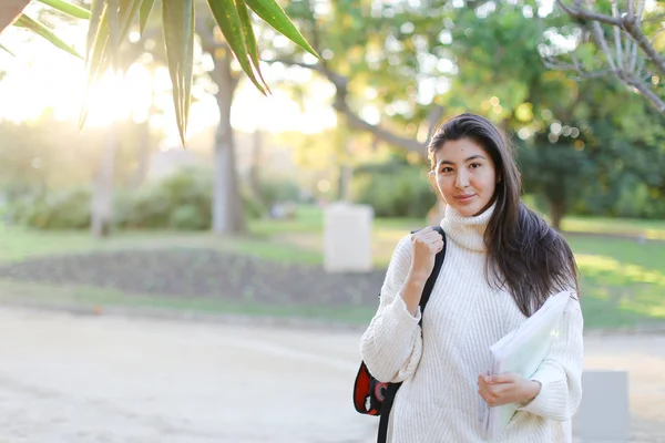 Menina coreana com documentos andando no parque . — Fotografia de Stock