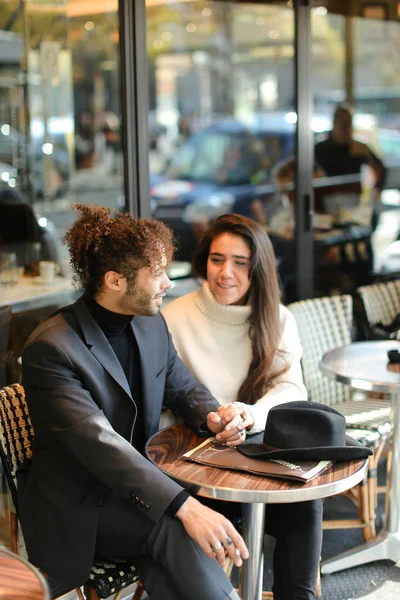 Hombre afroamericano y mujer caucásica sentados en la cafetería de la calle y hablando . —  Fotos de Stock