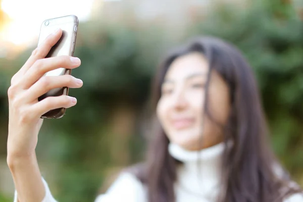 Enfoque en el teléfono inteligente, borrosa chica asiática haciendo selfie . — Foto de Stock