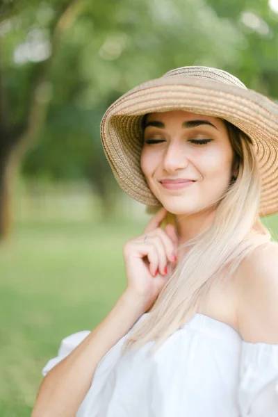 Porträtt av ung blond charmig kvinna bär hatt och ler. — Stockfoto