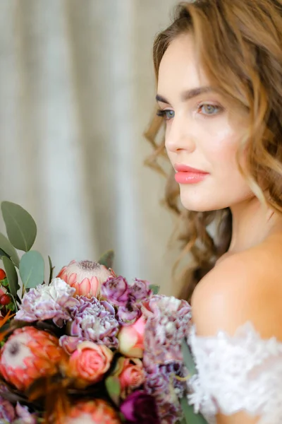 Κοντινό πορτρέτο της νεαρής νύφης με μπουκέτο λουλούδια στο φωτογραφείο. — Φωτογραφία Αρχείου