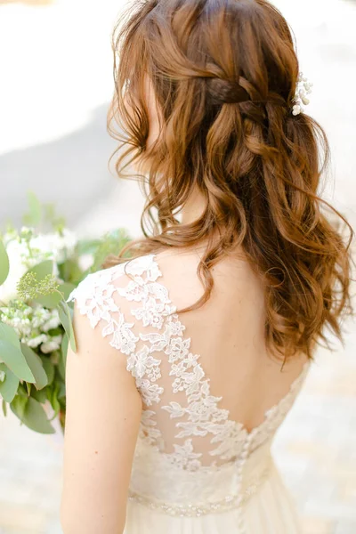 Vista posteriore dei capelli ricci fare per la sposa mantenere i fiori . — Foto Stock