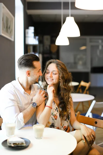 Junger hübscher Mann umarmt Ehefrau im Café und ruht sich aus. — Stockfoto