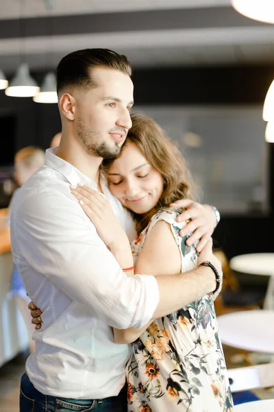 Kleiner hübscher Junge trägt weißes Hemd und umarmt hübsches Mädchen drinnen. — Stockfoto