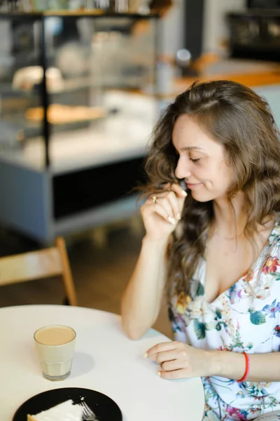 Młoda dziewczyna z filiżanki kawy siedząc w kawiarni i odpoczynku. — Zdjęcie stockowe