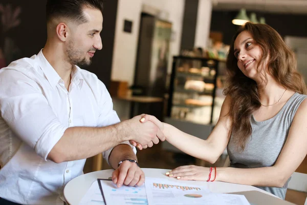 Exitoso hombre de negocios y mujer trabajando con documentos, estrechando la mano . — Foto de Stock