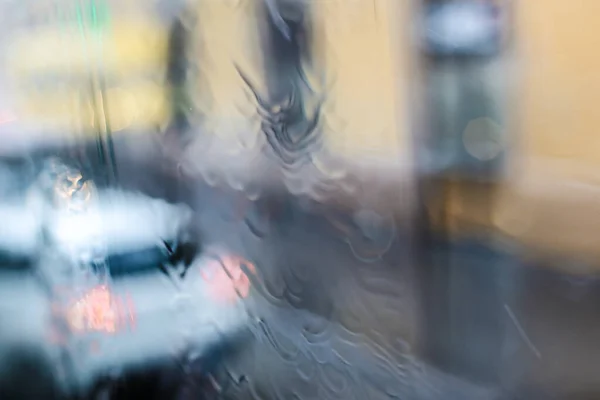 Βροχερή γυαλί και αυτοκίνητο στο παρασκήνιο, να επικεντρωθούν σε νερό. — Φωτογραφία Αρχείου