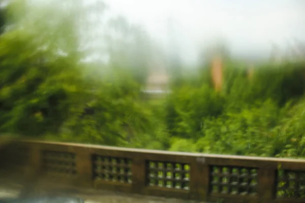 Balaustra in cemento sfocato con alberi verdi sullo sfondo . — Foto Stock
