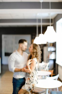 Kafede duran ve sarılan genç çiftin yumuşak odaklı fotoğrafı.