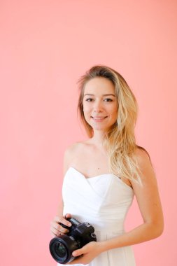 Genç kadın fotoğrafçı tek sesli pembe fotoğraf makinesi.