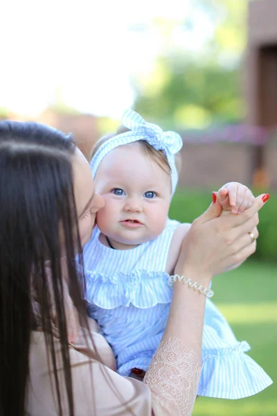 Primo piano felice madre aucasica che tiene piccolo bambino femmina in abito blu . — Foto Stock