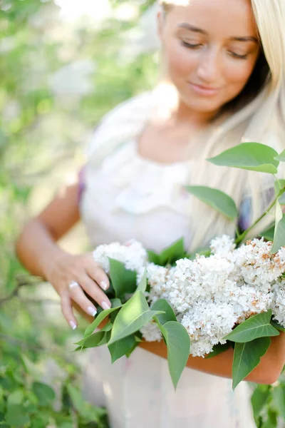 Fiatal szőke nő vezeti a fehér virágok. — Stock Fotó
