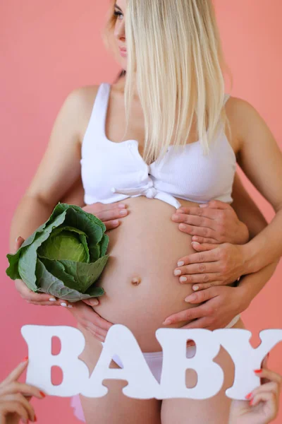 Primo piano donna bionda incinta in biancheria intima mantenendo iscrizione bambino e cavolo . — Foto Stock