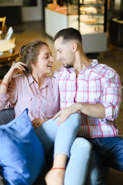 Jeune fille souriante assise avec son petit ami à l'intérieur et parlant . — Photo