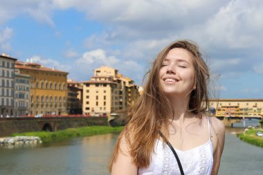 Mutlu kadın arka planda Arno Nehri ve binalar Floransa, İtalya.
