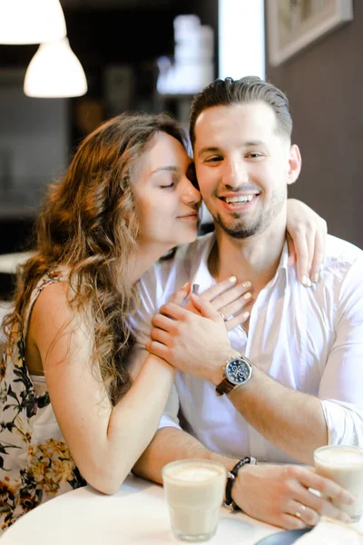 Junge Frau küsst Mann und sitzt im Café. — Stockfoto