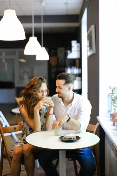 Joven pareja casada americana sentada en la cafetería y abrazándose . — Foto de Stock