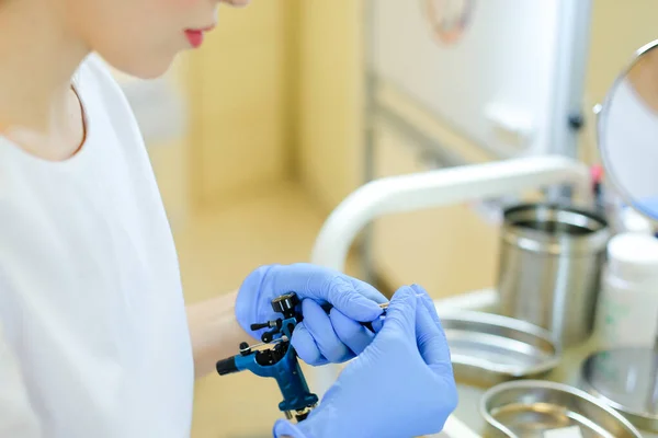 Κινηματογράφηση σε πρώτο πλάνο τα χέρια σε μπλε γάντια λατέξ εισαγωγή βελόνων σε microblading συσκευή. — Φωτογραφία Αρχείου