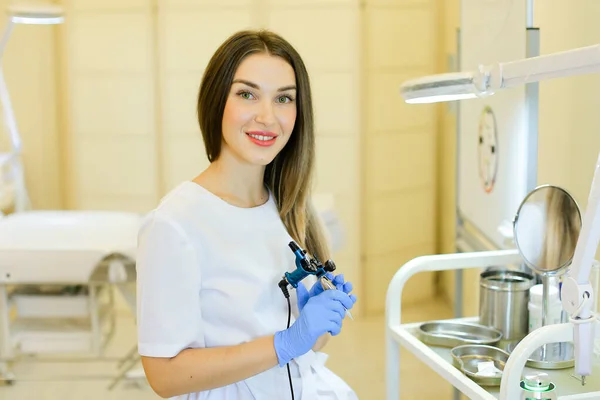 Young permanent makeup artist sitting with microblading device at beauty salon. — Stock Photo, Image