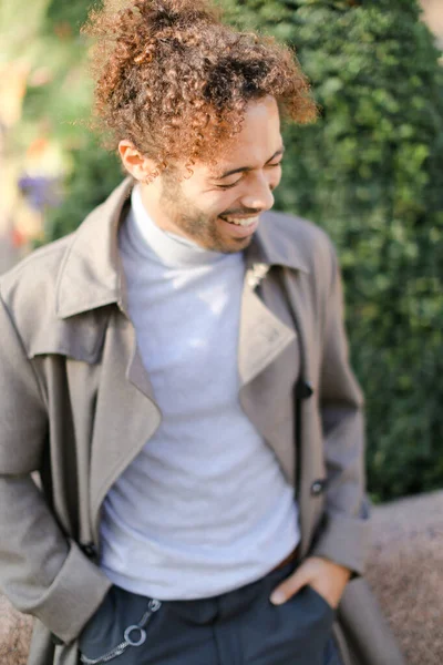 Afro americano hermoso hombre con pelo rizado sonriendo y de pie fuera . — Foto de Stock