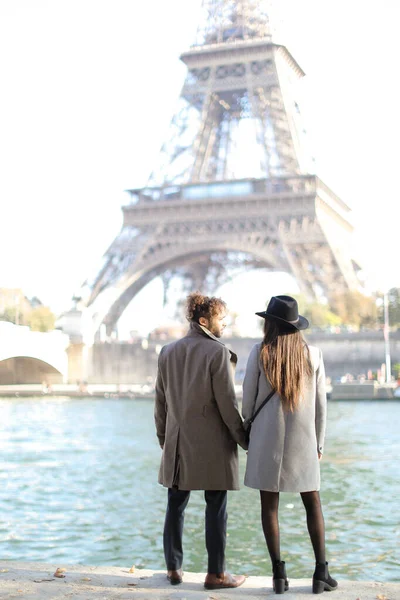 Visszapillantás afro amerikai férfi és lány áll közel Eiffel torony Párizsban. — Stock Fotó
