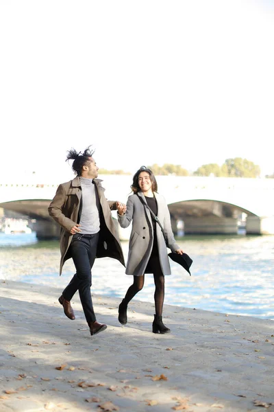 Niño afroamericano y chica caucásica corriendo cerca del puente del Sena, París . — Foto de Stock