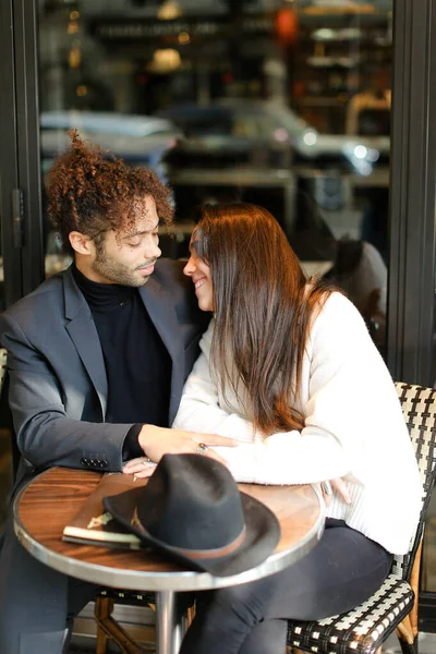 Afro americano hombre abrazando caucásico mujer y sentado en café . —  Fotos de Stock