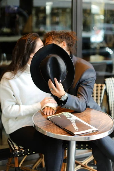 Foco em chapéu, homem afro-americano beijando mulher caucasiana no fundo . — Fotografia de Stock