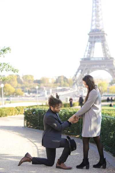 Joven afroamericano haciendo propuesta a novia caucásica en París, Torre Eiffel en el fondo . — Foto de Stock