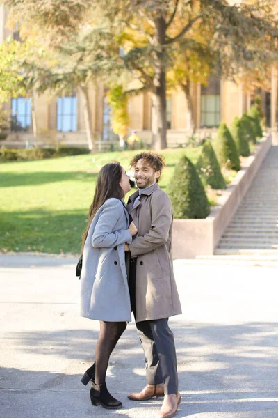 Afro-Amerikaanse jonge man knuffelen Kaukasische vrouw buiten. — Stockfoto