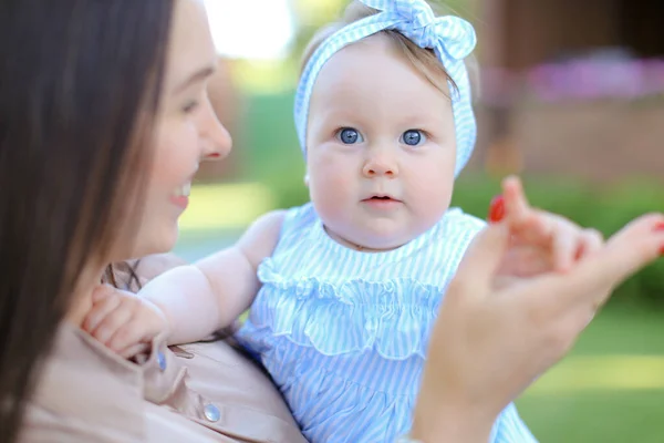 Primo piano europeo altro tenendo bambino piccolo femminile in abito blu . — Foto Stock