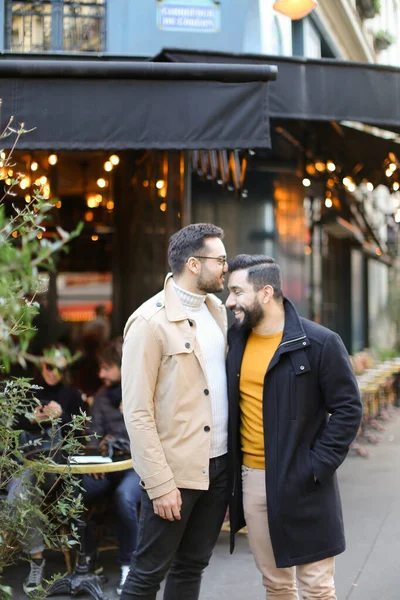 Twee vrolijke homo 's staan in de buurt van straat cafe en knuffelen . — Stockfoto
