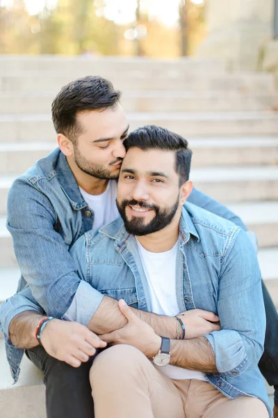 Kaukasische Schwule sitzen auf Betontreppen und küssen. — Stockfoto