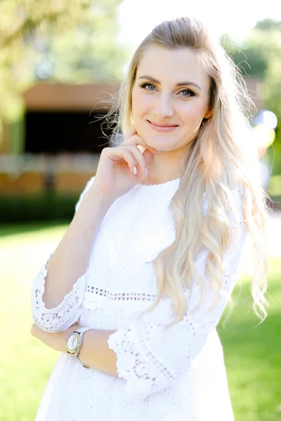 Portrait de jeune femme blonde souriante portant des vêtements blancs . — Photo