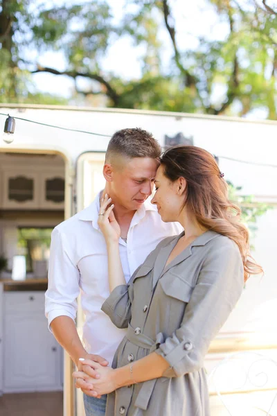 Portret van jonge vrouw knuffelende man in de buurt van huis op wielen. — Stockfoto