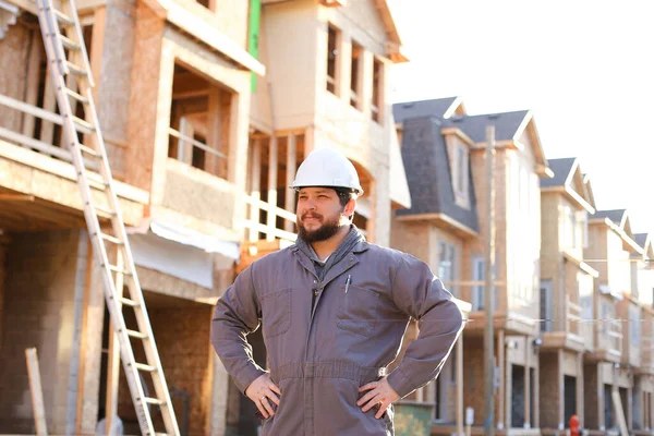 Construtor masculino vestindo chapéu duro em pé no canteiro de obras no Canadá . — Fotografia de Stock