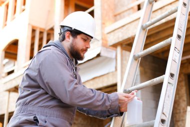 İnşaat alanında dezenfektan sabun kullanan genç mühendis.