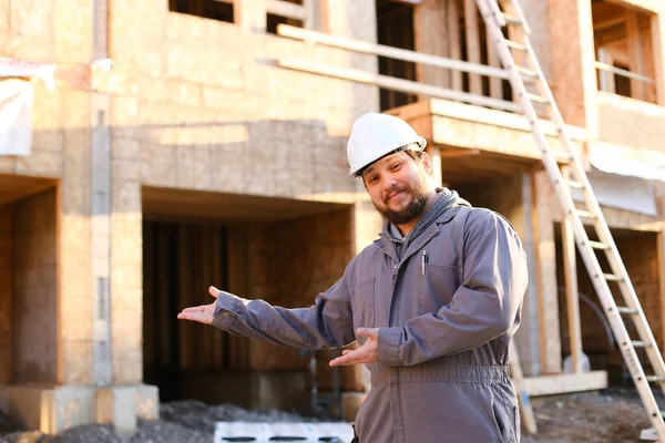 Портрет будівельника і майстра, що показує готове будівництво і носіння хардхату . — стокове фото