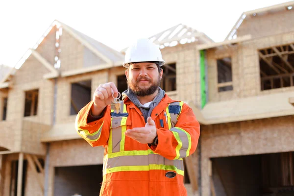 Portret van een blanke ingenieur die sleutels geeft van een nieuw huis.. — Stockfoto