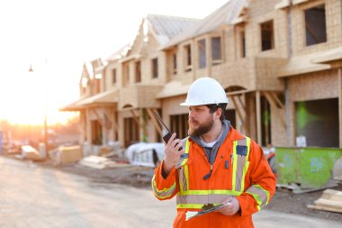 Foreman inşaat alanında telsizle konuşuyor..