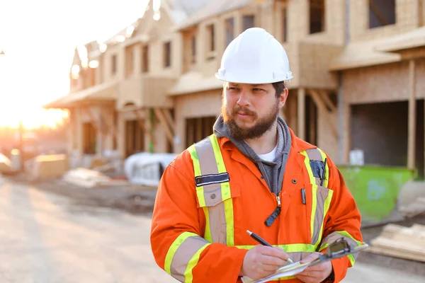 Engenheiro escrevendo em notebook no canteiro de obras . — Fotografia de Stock