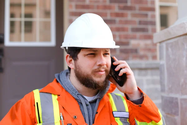 Πορτρέτο του επιστάτη σε hardhat talkign από το smartphone έξω. — Φωτογραφία Αρχείου