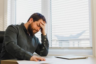 Ofisteki belgelerle uğraşmaktan yorgun düşmüş patron, masadaki bilgisayarı kapatmış..