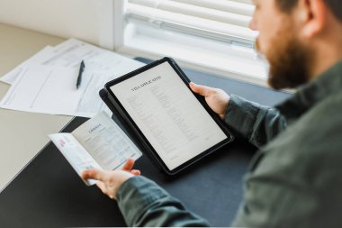 Vize başvurusu yapan adam tablet ve pasaport tutuyor, Kanada.