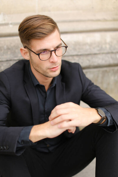 Portrait of businessman wearing black suit and glasses.