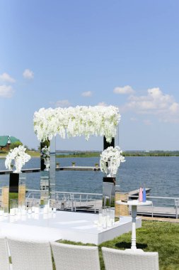 Arkasında göl olan güzel bir düğün sunağı..
